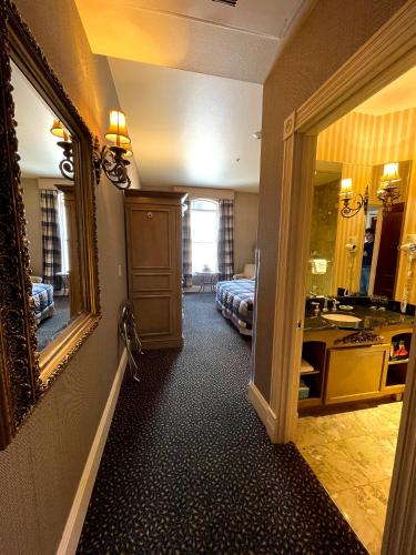 a hotel room with a bed and a sink and a mirror at Celebrity Boutique Hotel in Deadwood