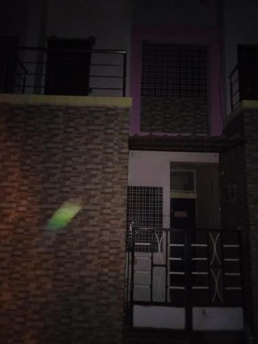 a green light on the side of a brick building at Sandhiya Villa 1bhk in Bharbharia
