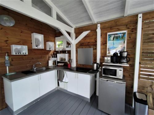 a kitchen with white appliances and wooden walls at Kazalao in Prise dʼEau