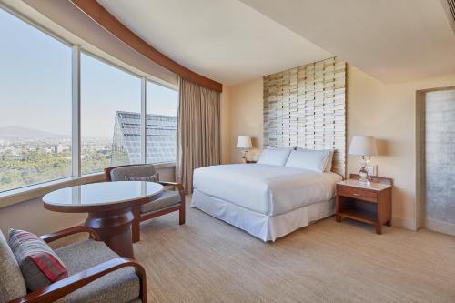 a hotel room with a bed and a large window at Grand Fiesta Americana Guadalajara Country Club in Guadalajara