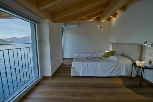 a bedroom with a bed and a large window at Appartamento Comballo in Lezzeno