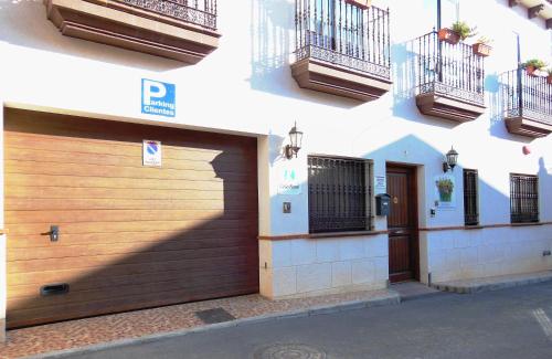 a building with a wooden garage door and balcony at Casa Rural Jardín del Desierto in Tabernas