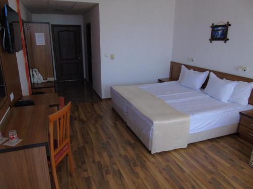 a bedroom with a large bed and a wooden floor at Jupiter Hotel in Sunny Beach