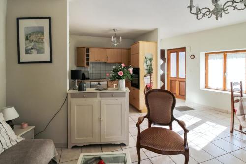 Il comprend un salon avec deux chaises et une cuisine. dans l'établissement Maison confortable Ornans + Jardin, à Ornans