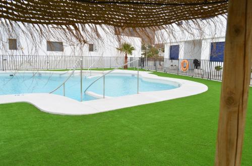 una piscina en un patio con césped verde en Casas la Noria, en Las Negras
