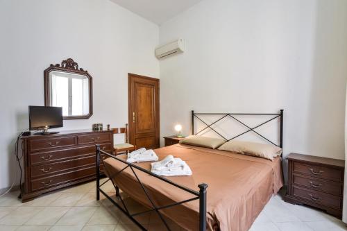 a bedroom with a bed and a dresser and a mirror at Apartment with balcony in Porto Santo Stefano 89 m² sea view in Porto Santo Stefano