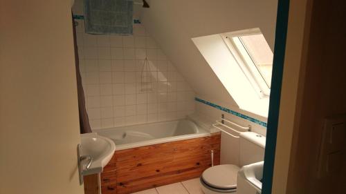 Un baño con bañera, inodoro y lavabo. en Le Petit Courtoux, en Saint-Germain-en-Coglès