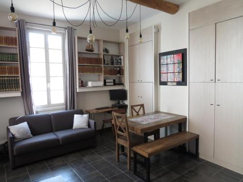 uma sala de estar com um sofá e uma mesa em Appartement avec jardin privatif em Fréjus