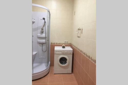 a bathroom with a washing machine and a shower at Двухкомнатная посуточно на ул. Ватутина, 18 in Omsk