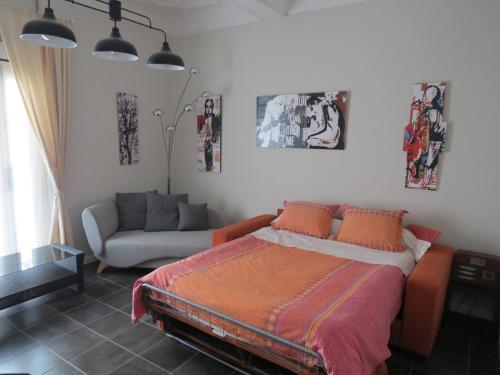 um quarto com uma cama e um sofá em Appartement avec jardin privatif em Fréjus