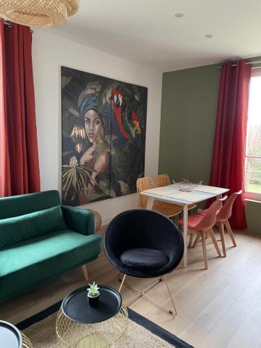 un salon avec un canapé vert et une table dans l'établissement Villa saint Louis 3, à Cabourg