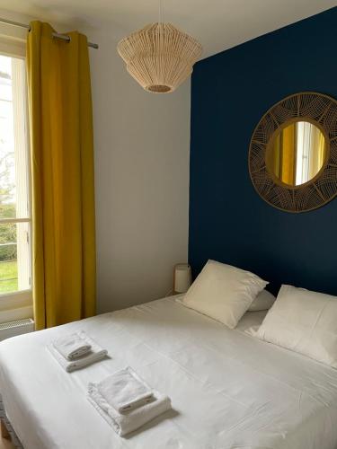 une chambre avec un lit blanc et un miroir dans l'établissement Villa saint Louis 3, à Cabourg