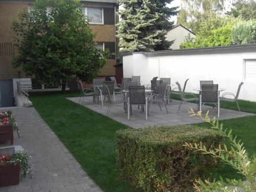 a patio with chairs and tables in a yard at Centralhotel Ratingen in Ratingen