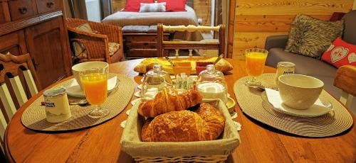 a table with a tray of croissants and orange juice at La grange de Lina in Grignon