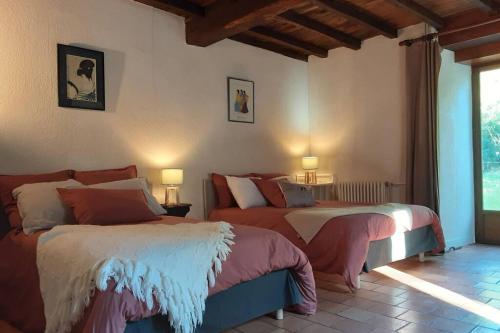 a bedroom with two beds and a window at Maison de charme confortable au cœur de la nature in Saint-André-de-Double