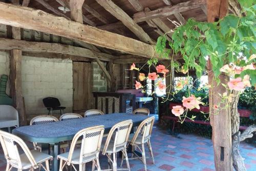 une table bleue et des chaises dans une pièce fleurie dans l'établissement Maison de charme confortable au cœur de la nature, à Saint-André-de-Double