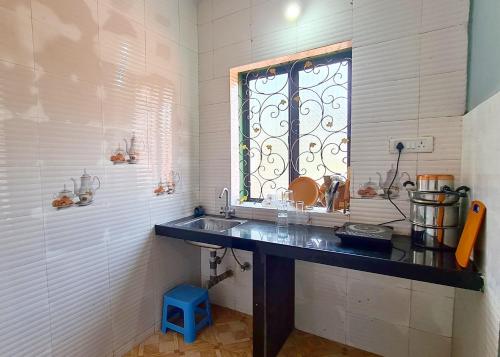 ein Bad mit einem Waschbecken und einem Fenster in der Unterkunft Jackson's Beach House Calangute in Calangute