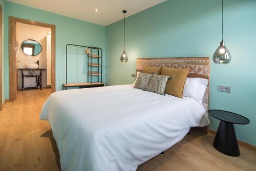 a bedroom with a large white bed and a table at AGROTURISMO ZUMINTXAZ in Mungia