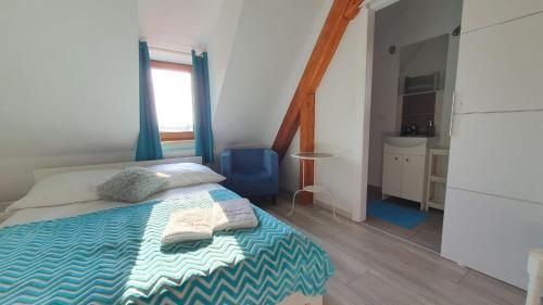 a bedroom with a bed and a blue chair at Parkowy Kudowa in Kudowa-Zdrój