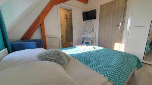 a bedroom with a bed with a blue and white blanket at Parkowy Kudowa in Kudowa-Zdrój
