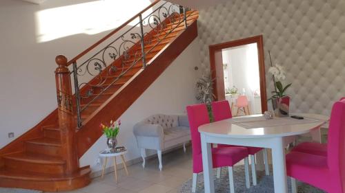 uma sala de estar com uma escada e uma mesa e cadeiras em Parkowy Kudowa em Kudowa-Zdrój