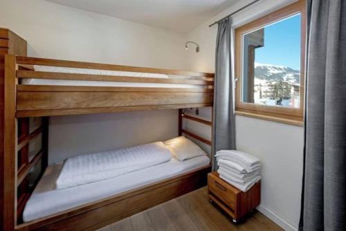 a bedroom with a bunk bed and a window at Lovely Spacious Apartment Gerlos -Owner- in Gerlos