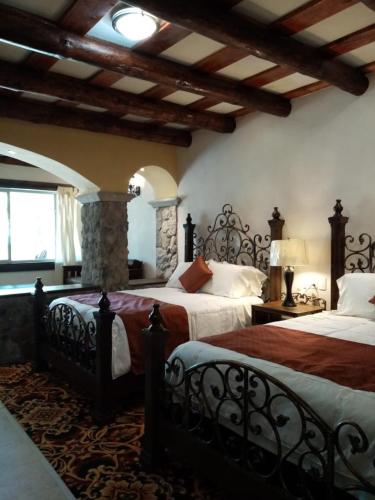 a large bedroom with two beds and a fireplace at Hotel Quinta Mision in Creel