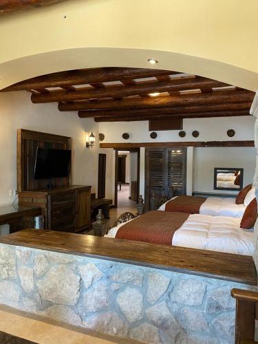 a bedroom with a large bed and a television at Hotel Quinta Mision in Creel