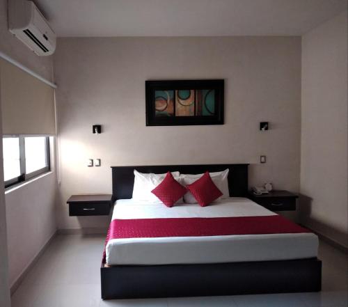 トゥストラ・グティエレスにあるHotel Madridのベッドルーム1室(大型ベッド1台、赤い枕付)