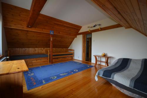 1 dormitorio con cama y alfombra azul en usokoła, en Gawrych Ruda