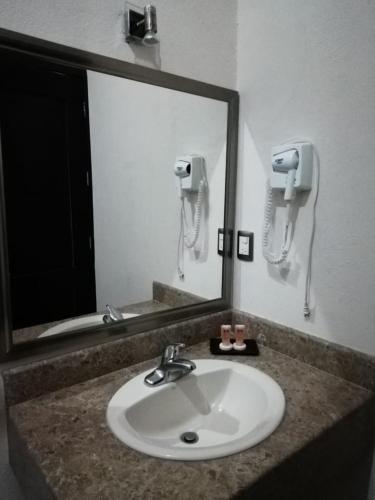 a bathroom sink with a mirror and a phone at Hotel Madrid in Tuxtla Gutiérrez