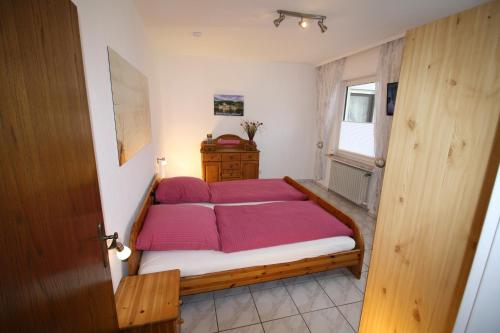 a bedroom with a bed with red pillows on it at Komfort Ferienwohnung FEWO74-2 in Bremm