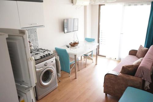 uma cozinha com um fogão e uma mesa com cadeiras em Ören Konak Apart Otel em Burhaniye