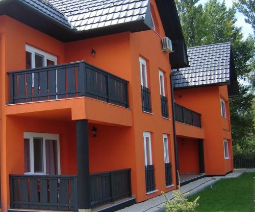 un edificio anaranjado con un balcón en el lateral. en Rider Beach, en Balatonszemes