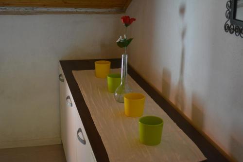 un mostrador con tazas amarillas y un jarrón con una flor en Apartman Bernardica, en Bol