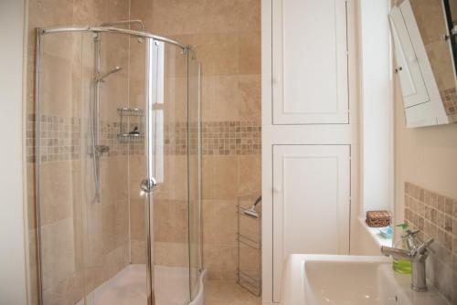 a shower with a glass door next to a sink at Tower House, Aldeburgh in Aldeburgh
