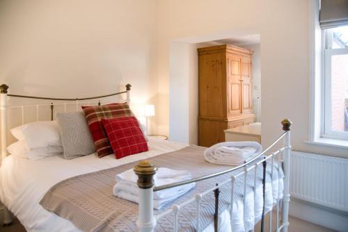 a bedroom with a white bed with red pillows at Tower House, Aldeburgh in Aldeburgh