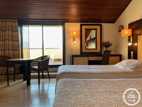 a hotel room with a bed and a table and a window at Discovery Apartment Carnaxide in Carnaxide
