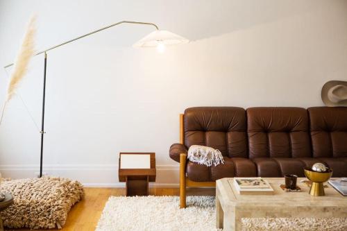 a living room with a brown couch and a table at Object Hotel 2BR Room 2A in Bisbee