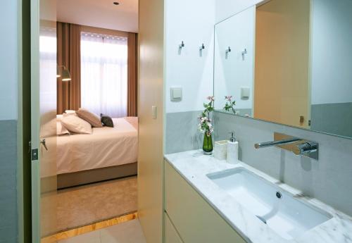 a bathroom with a sink and a bed at ChillHouse_Porto - Praça da República in Porto