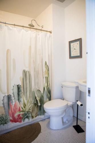 a bathroom with a toilet and a cactus shower curtain at Object Hotel 1BR Shared Bath Room 2C in Bisbee