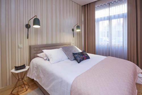 a bedroom with a bed with white sheets and a window at ChillHouse_Porto - Praça da República in Porto