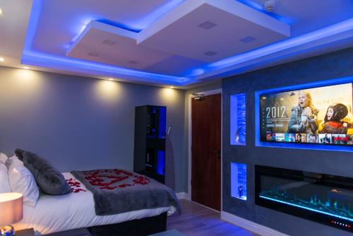 a room with a bed and a flat screen tv at Sawrey Serviced Apartments in Bradford