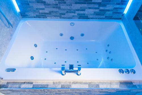 a bathtub in a room with a brick wall at Sawrey Serviced Apartments in Bradford