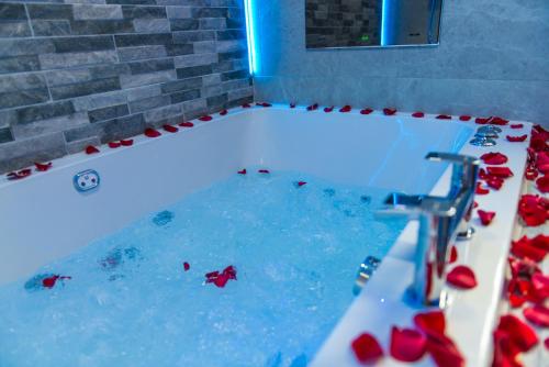 a tub filled with water with red roses in it at Sawrey Serviced Apartments in Bradford