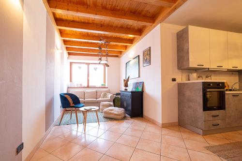 Una sala de estar con un sofá y una cocina. en Le Muse, Comano Terme Holiday - piano terra, en Comano Terme