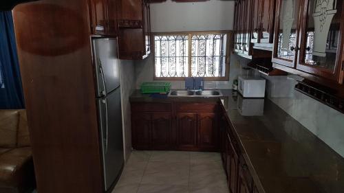 a kitchen with wooden cabinets and a stainless steel refrigerator at Casa amueblada - Mazatlán in Mazatlán