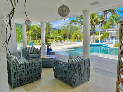 a patio with chairs and a swimming pool at Condomínio Costa Verde Tabatinga in Mocoóca