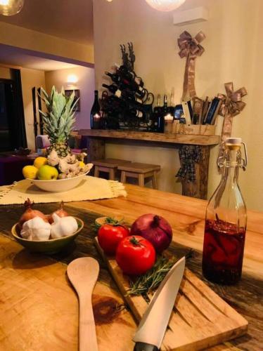 a wooden table with vegetables and a bottle of sauce at Vila Dragana in Žabljak