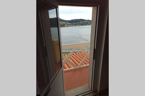a view of the ocean from a window at Casa da Costa - Apartamento con terraza y vistas al mar in Cedeira